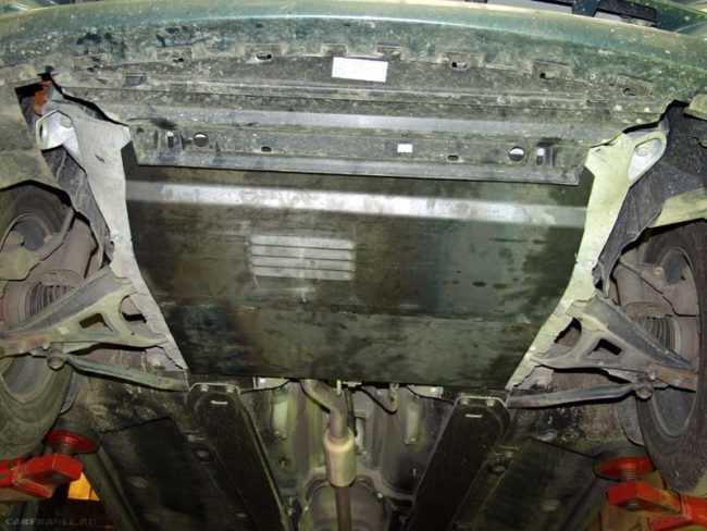 Процесс демонтажа защитного кожуха картера Рено Симбол, вид из-под машины