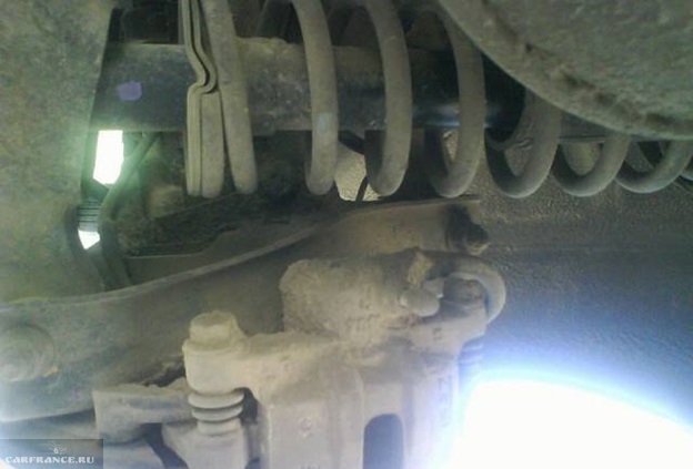 Грязное крепление тормозных суппортов на заднем колесе седана Митсубиси Лансер 9