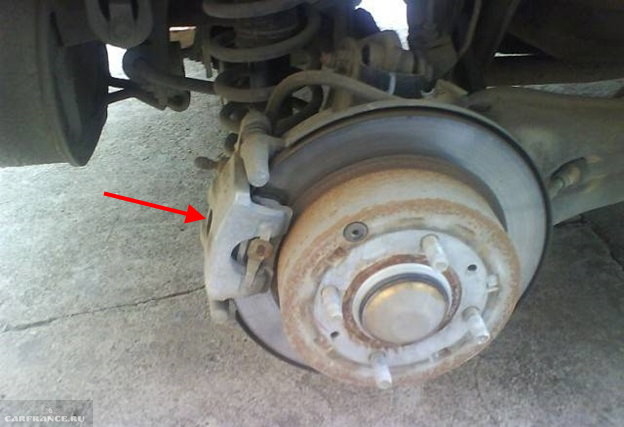Тормозной суппорт на заднем колесе Митсубиси Лансер 9, вид со снятым колесом